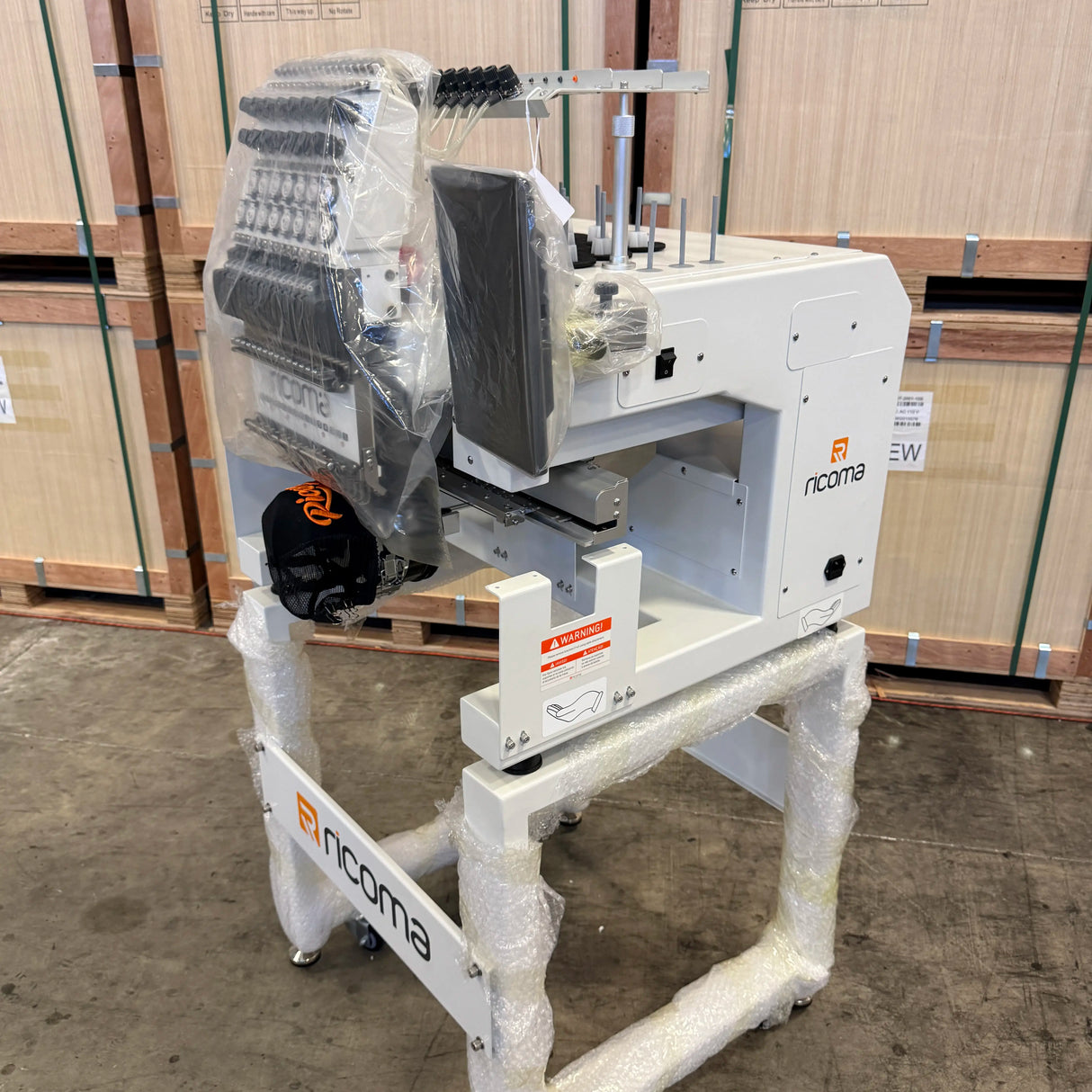 Industrial machine with 'nicoma' branding on a pallet in an indoor setting