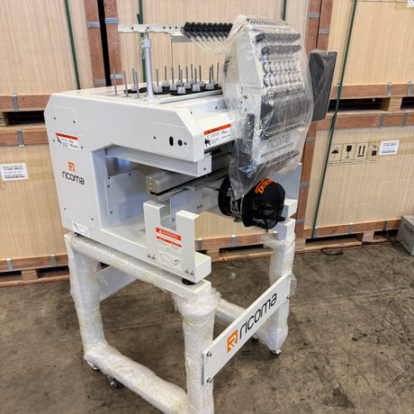 White machine with 'nicoma' branding on a concrete floor with cardboard boxes in the background